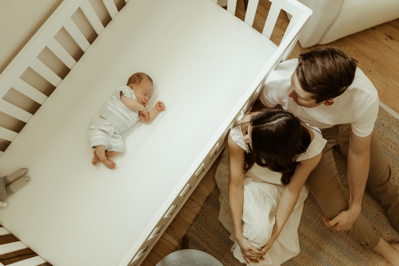 Newborn Photography, Baby in a crib with parents looking in